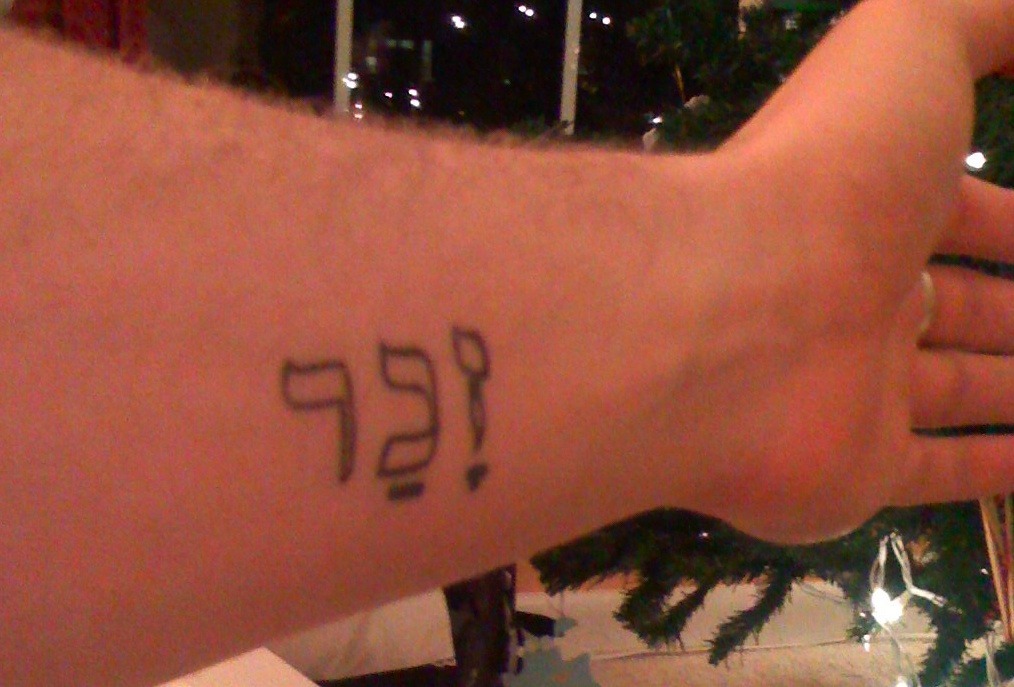  his sleeve to reveal the Hebrew word Zakhar tattooed on his forearm